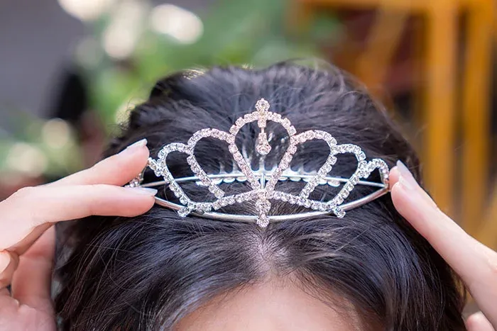 Girl in tiara representing children burdened with unusual parental name choices.