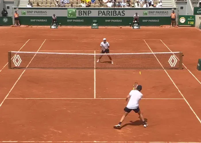 Tennis match action on clay court during incident controversy