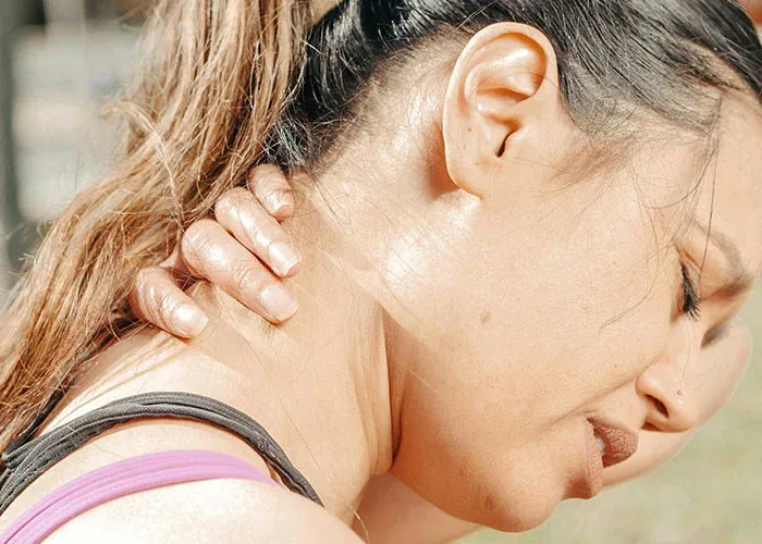 Woman experiencing neck pain from life stress