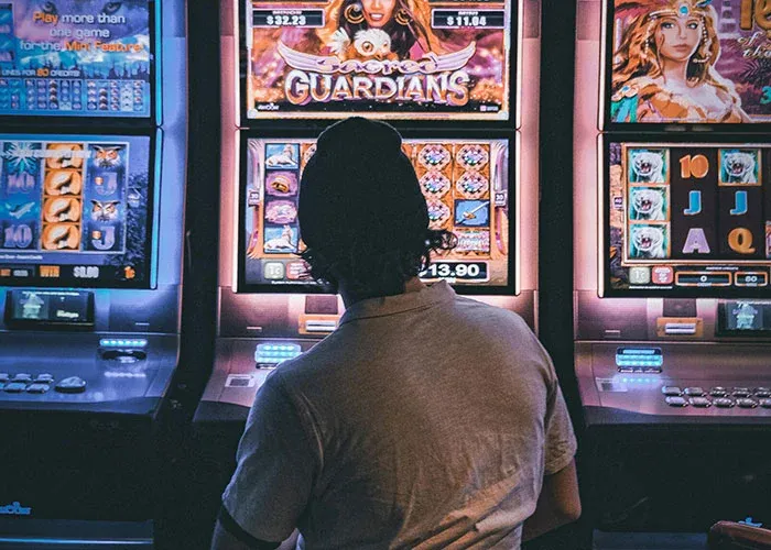 Person gambling on slot machines risking financial ruin