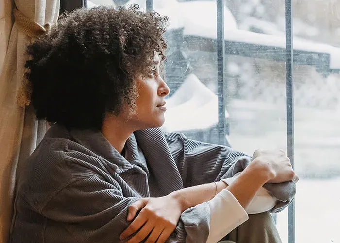 Person looking out window contemplating life choices