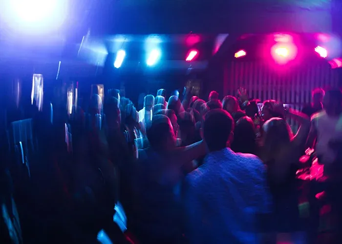 People dancing at party with colorful lights