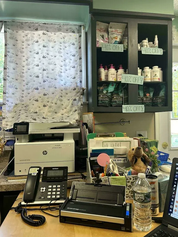Office desk with printer, phone, supplies, and pet products with 40 percent off signs